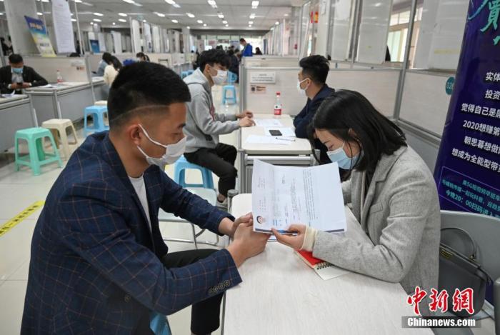 4月14日，招聘者在查看求職者簡(jiǎn)歷。<a target='_blank'  data-cke-saved- >中新社</a>記者 王剛 攝