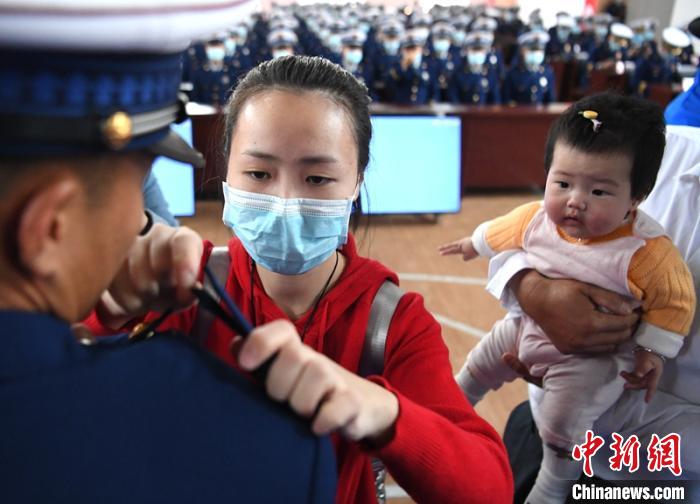 新消防員楊振的妻子彭莉與女兒現(xiàn)場(chǎng)見證丈夫加入“火焰藍(lán)”的神圣時(shí)刻?！⒅铱?攝