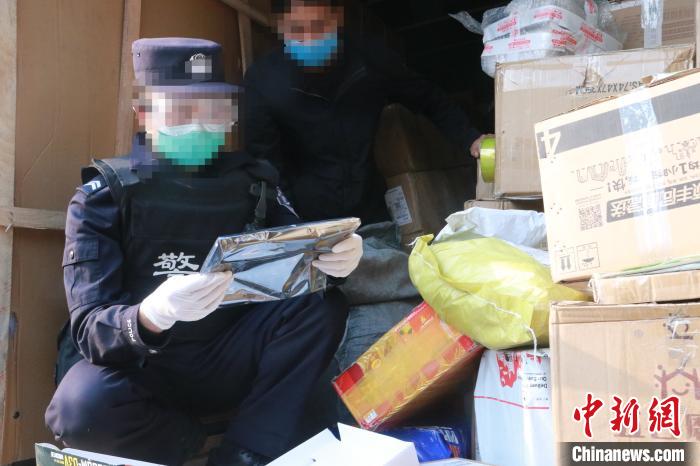 圖為勐康邊檢站民警在對(duì)快遞運(yùn)輸車輛進(jìn)行例行檢查。　楊添 攝