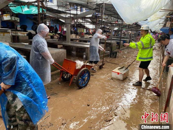 圖為7月26日，暴雨引發(fā)的洪水過境后，重慶萬州區(qū)分水鎮(zhèn)政府干部職工及志愿者清掃淤泥和垃圾?！　≈貞c萬州區(qū)委宣傳部供圖 攝