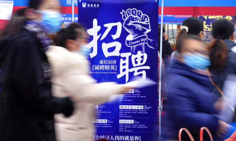 求職者從一家招聘企業(yè)的廣告牌前走過。新華社發(fā)（苑立偉 攝）