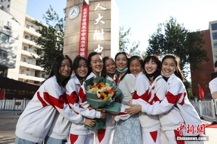 資料圖：6月10日，在北京人大附中高考考點(diǎn)外，考生們相擁拍照留念。當(dāng)日，北京市2021年高考結(jié)束?！?<a target='_blank'  data-cke-saved- ><p  align=